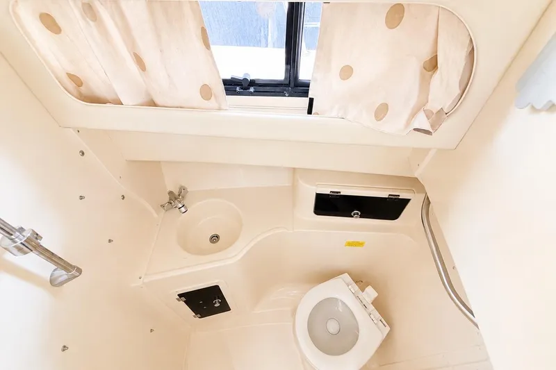 Slide: The Image of 2007 Grady-White Marlin 300 boat bathroom with sink, toilet, and window curtains. - 12