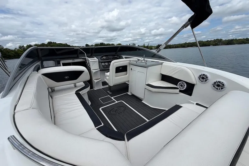 Slide: The Image of Luxurious 2008 Cobalt 303 boat interior with white seating and sleek dashboard on a calm lake. - 21