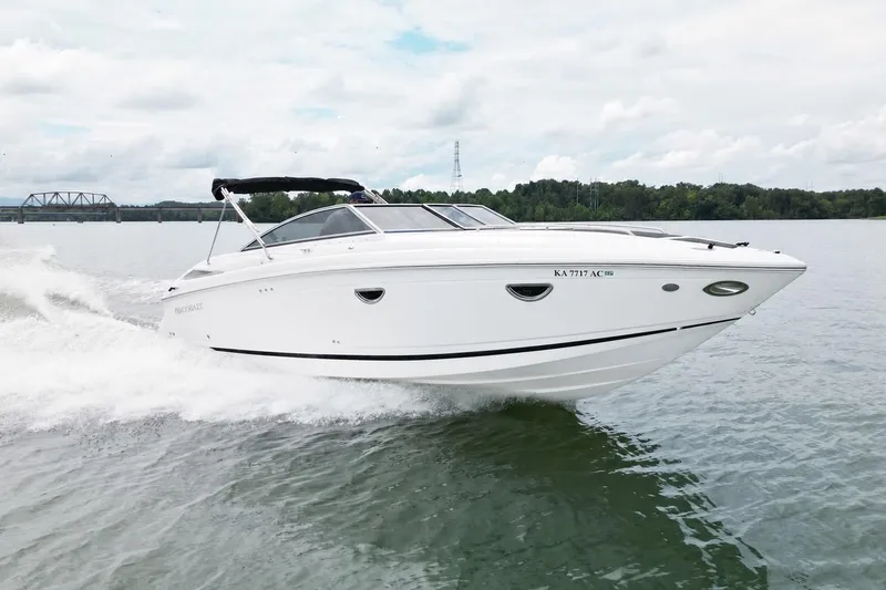 Slide: The Image of 2008 Cobalt 303 boat cruising on a lake with a scenic background. - 8
