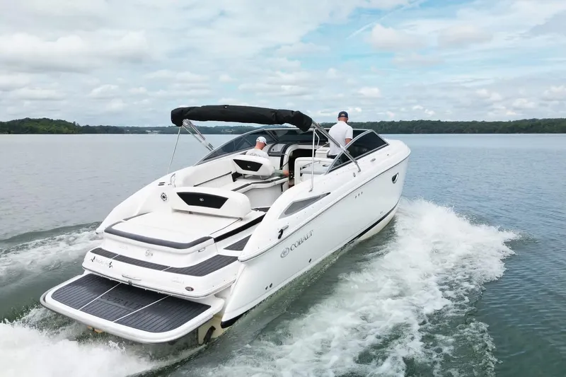 Slide: The Image of 2008 Cobalt 303 boat cruising on a serene lake under a cloudy sky. - 6