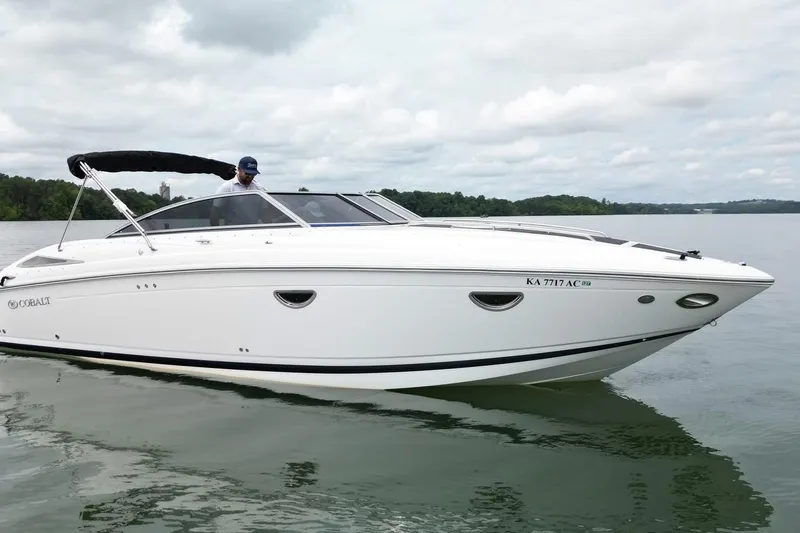 The Image of 2008 Cobalt 303 boat on calm water with a person at the helm. - 0