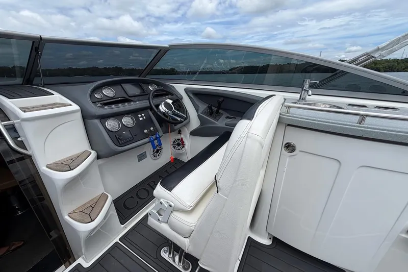 Slide: The Image of 2008 Cobalt 303 boat cockpit with steering wheel, dashboard, and seating under a cloudy sky. - 18