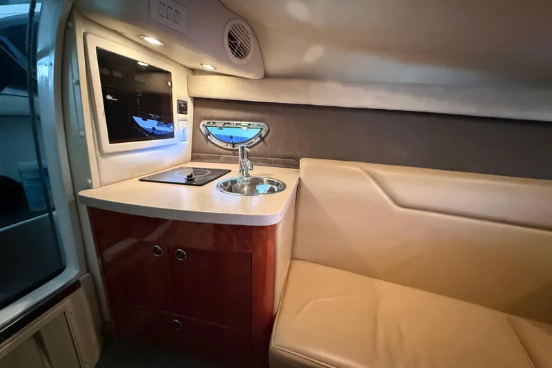 Slide: The Image of 2008 Cobalt 303 boat interior with kitchenette and seating area. - 24