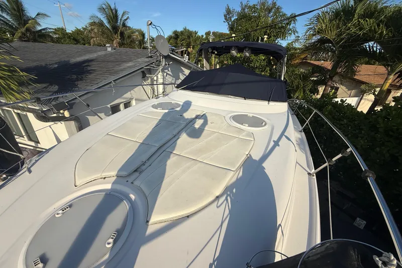Slide: The Image of 2006 Four Winns 328 Vista boat deck with sun pads and canopy, surrounded by palm trees. - 62