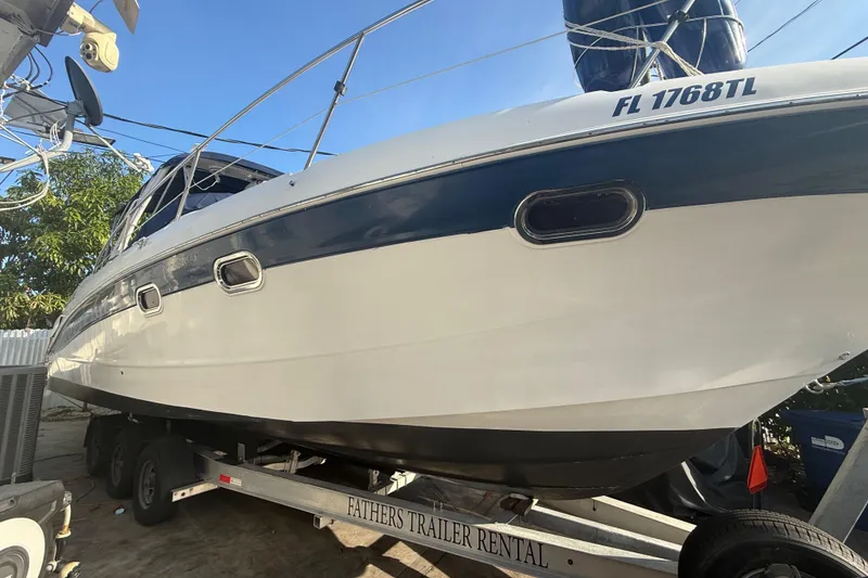 Slide: The Image of 2006 Four Winns 328 Vista boat on trailer, side view with registration number visible. - 12