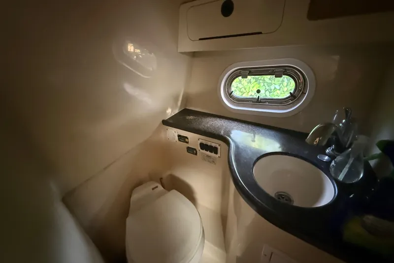 Slide: The Image of 2006 Four Winns 328 Vista boat bathroom with sink, toilet, and porthole window. - 51
