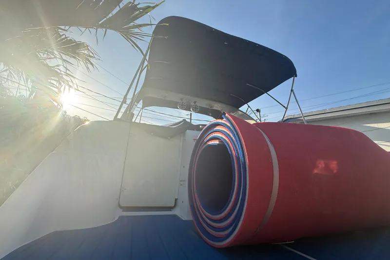 Slide: The Image of 2006 Four Winns 328 Vista boat with rolled-up red mat on deck, sunny day. - 34