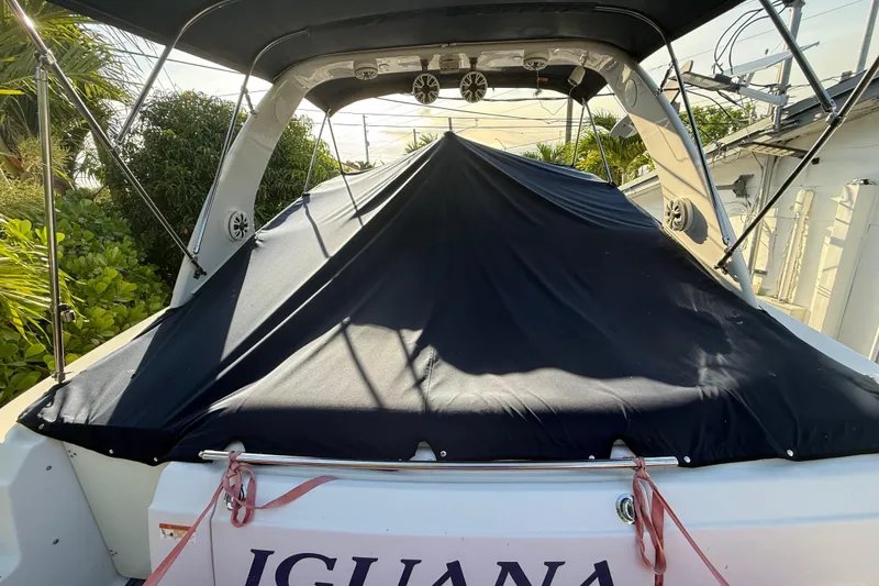 Slide: The Image of 2006 Four Winns 328 Vista boat covered, docked outdoors with lush greenery. - 36