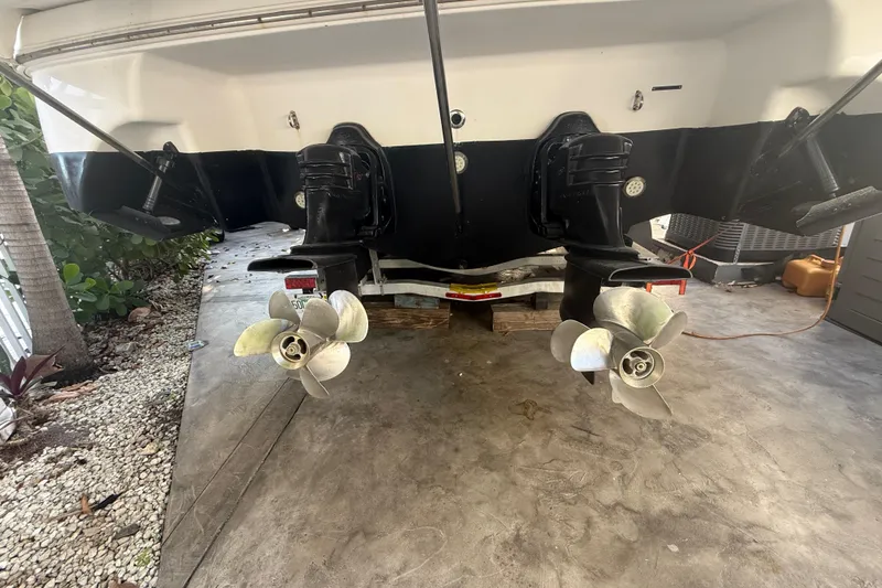 Slide: The Image of 2006 Four Winns 328 Vista boat stern with dual propellers in a garage setting. - 26