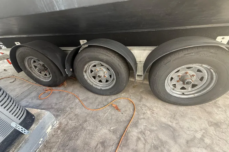 Slide: The Image of Triple axle trailer for 2006 Four Winns 328 Vista boat, parked on concrete. - 15