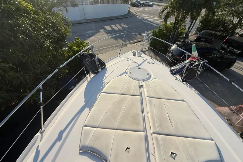 Slide: The Image of 2006 Four Winns 328 Vista boat deck with sun pad and railing, docked near palm trees. - 59