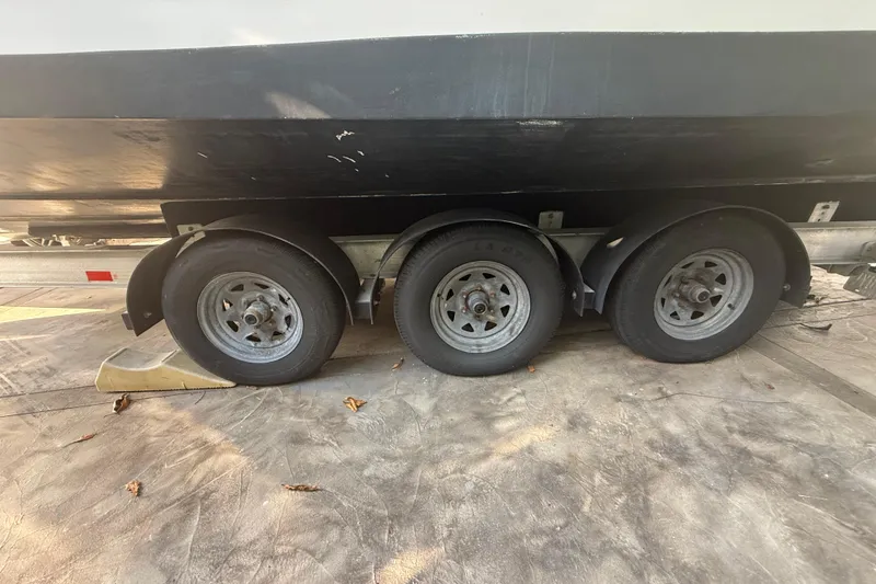 Slide: The Image of Trailer with three wheels supporting a 2006 Four Winns 328 Vista boat. - 23