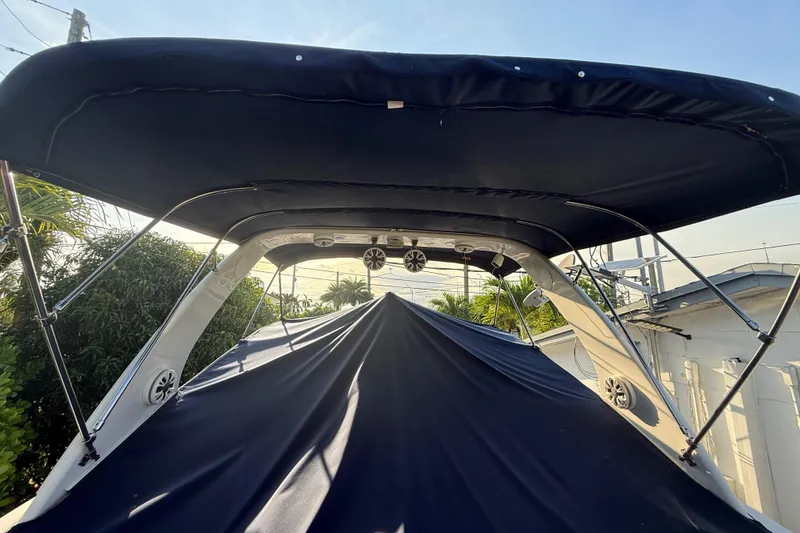 Slide: The Image of 2006 Four Winns 328 Vista boat with canopy and speakers, docked outdoors. - 56