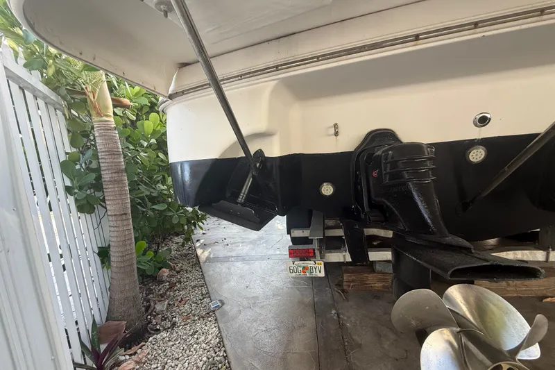 Slide: The Image of Rear view of a 2006 Four Winns 328 Vista boat on a trailer, showing propeller and outdrive. - 32