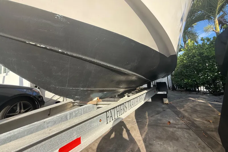 Slide: The Image of 2006 Four Winns 328 Vista boat on trailer, parked outdoors near greenery. - 20