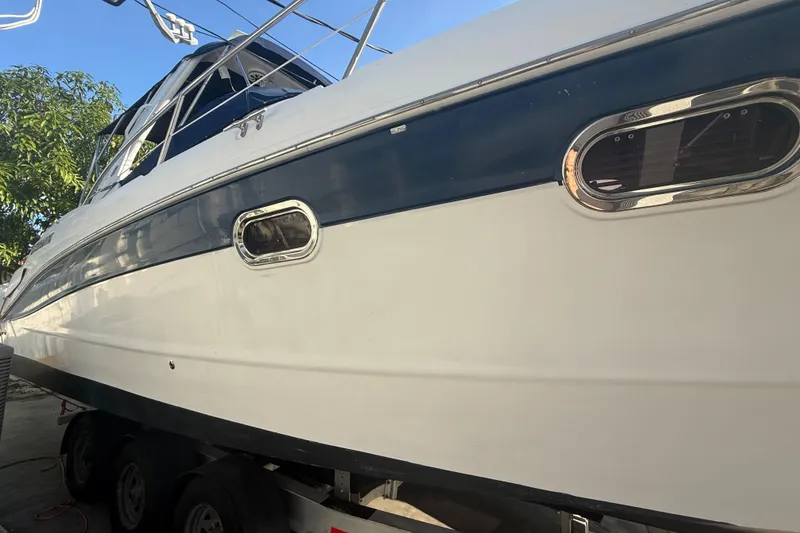 Slide: The Image of 2006 Four Winns 328 Vista boat on trailer, side view with blue and white exterior. - 13
