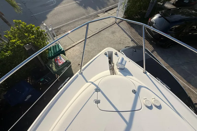 Slide: The Image of Bow view of 2006 Four Winns 328 Vista boat docked near a driveway. - 60