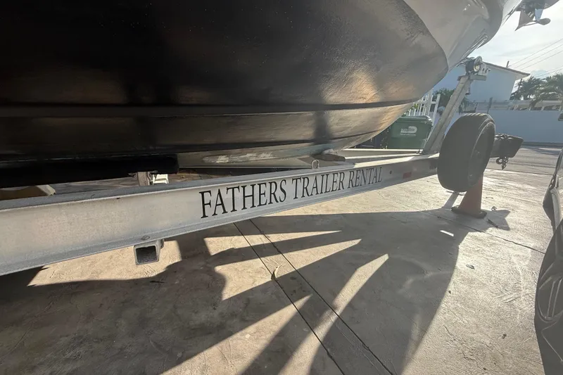 Slide: The Image of Trailer with "Fathers Trailer Rental" text, holding a 2006 Four Winns 328 Vista boat. - 16