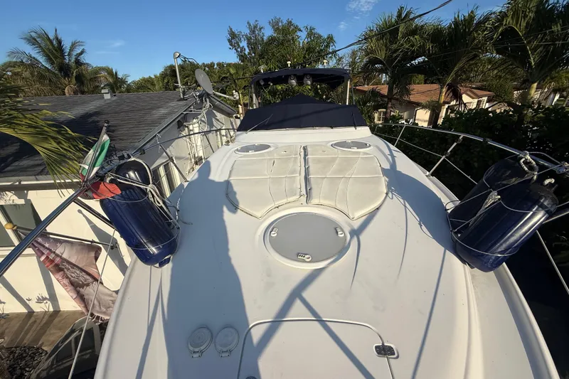 Slide: The Image of 2006 Four Winns 328 Vista boat deck with cushions and fenders, surrounded by palm trees. - 65