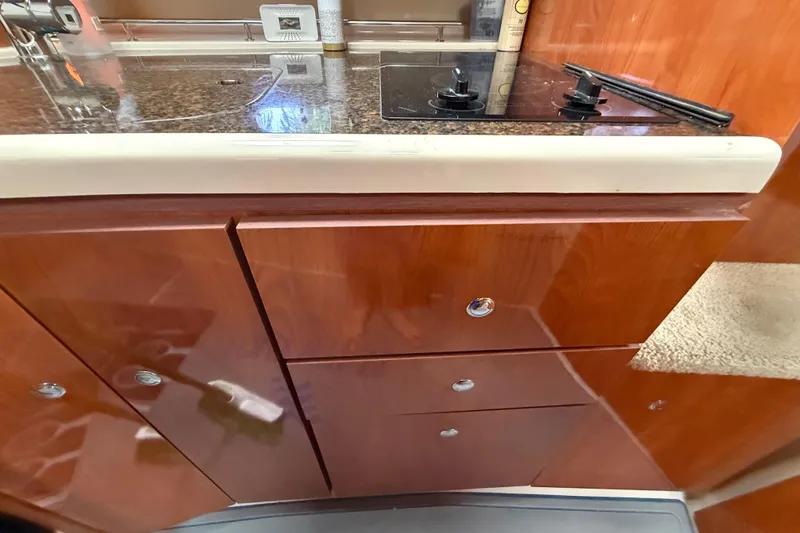 Slide: The Image of 2006 Four Winns 328 Vista kitchen area with wooden cabinets and a sleek countertop. - 48