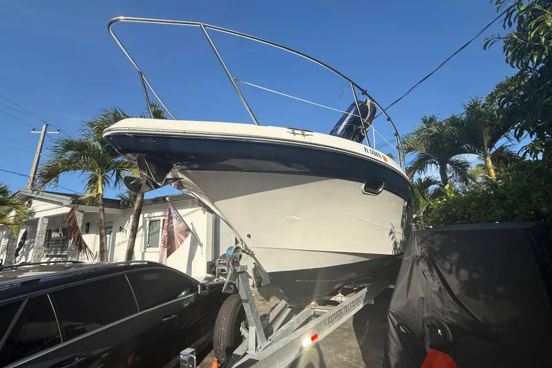 Slide: The Image of 2006 Four Winns 328 Vista boat on trailer, parked near palm trees and a house. - 8