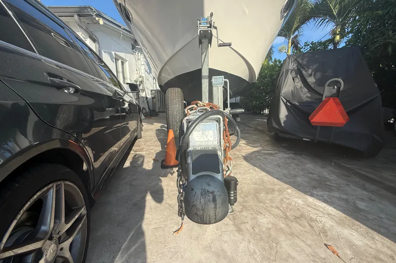 Slide: The Image of 2006 Four Winns 328 Vista boat on trailer beside parked car and covered vehicle. - 6