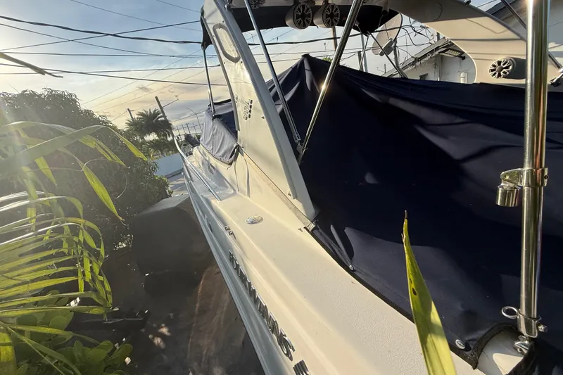 Slide: The Image of 2006 Four Winns 328 Vista boat with blue cover, surrounded by tropical foliage. - 57