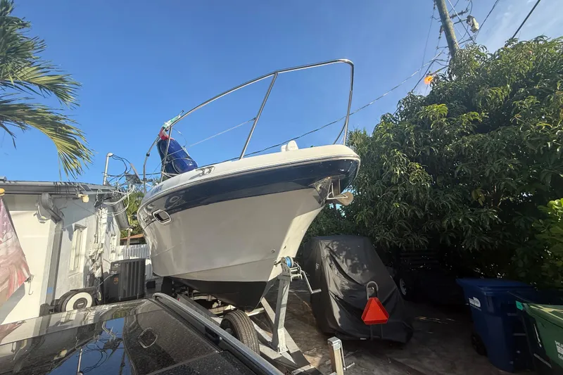 Slide: The Image of 2006 Four Winns 328 Vista boat on trailer, surrounded by trees and buildings. - 10
