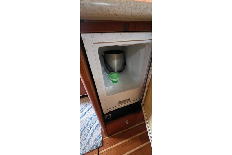 Slide: The Image of Small refrigerator inside 2004 Tiara Yachts 4000 Express, containing a green cup and a pot. - 14
