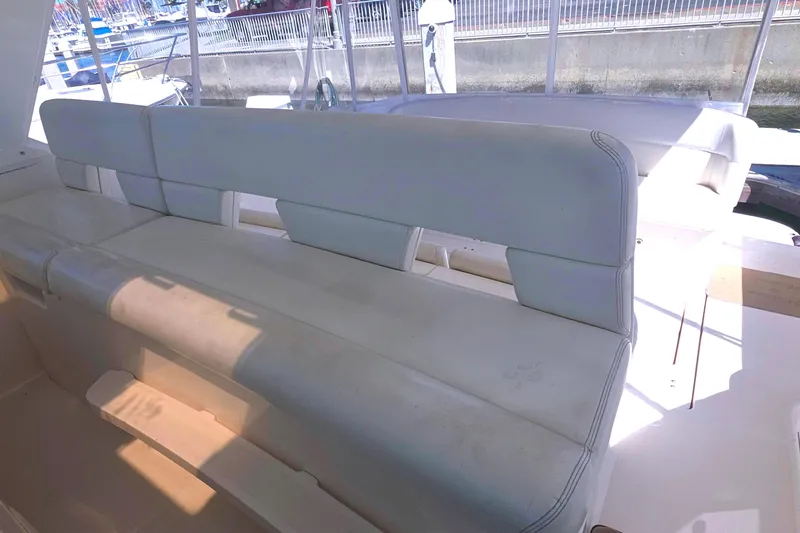 Slide: The Image of 2004 Tiara Yachts 4000 Express interior seating, featuring white cushioned benches. - 32