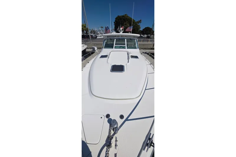 Slide: The Image of 2004 Tiara Yachts 4000 Express boat docked, showcasing sleek white deck design. - 40