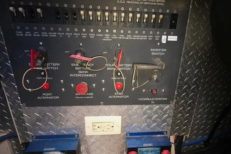 Slide: The Image of Control panel of a 2004 Tiara Yachts 4000 Express, featuring battery switches and alternators. - 53