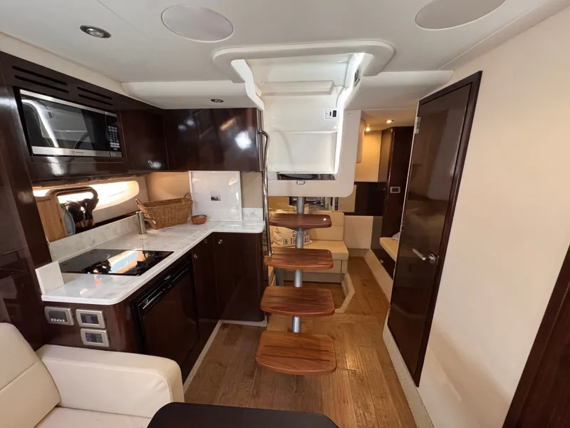 Slide: The Image of Interior of the 2018 Sea Ray Sundancer 350 with kitchen and seating area. - 32