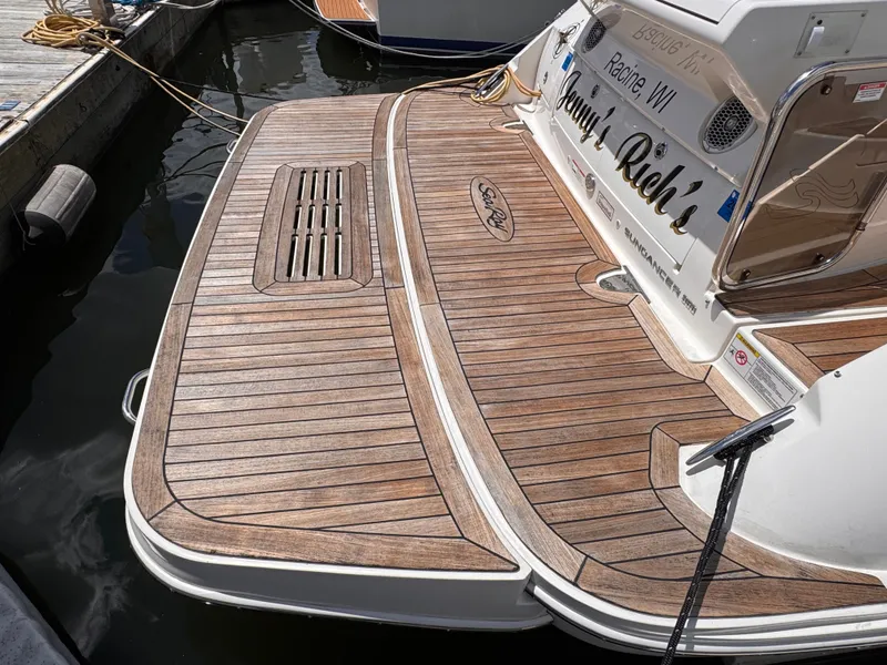 Slide: The Image of The image shows the stern of a Sea Ray Sundancer 350 with a wooden deck by the water. - 7