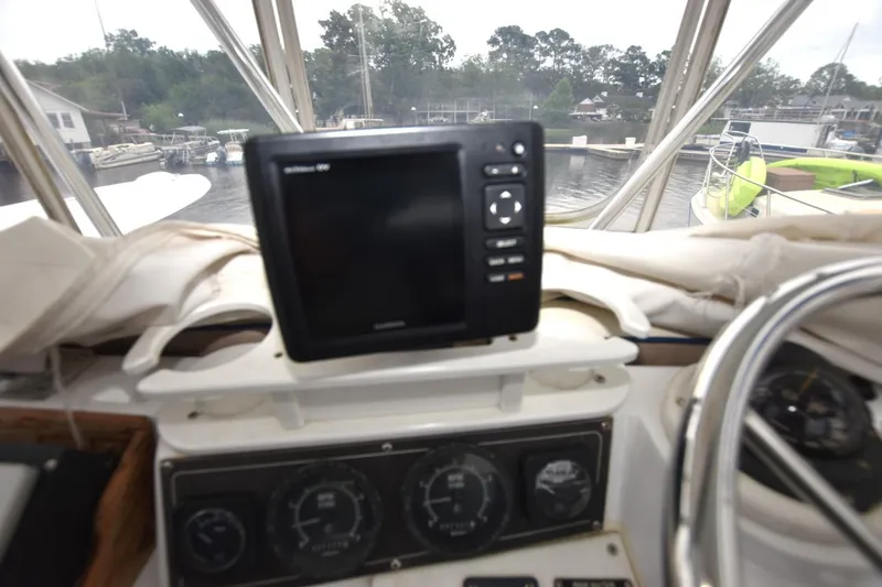Slide: The Image of 1981 Blackfin 32 Sportfisherman helm with navigation equipment and gauges, docked at marina. - 14