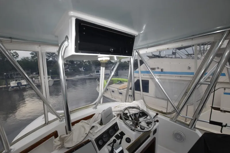 Slide: The Image of Interior view of 1981 Blackfin 32 Sportfisherman boat helm with marina background. - 16