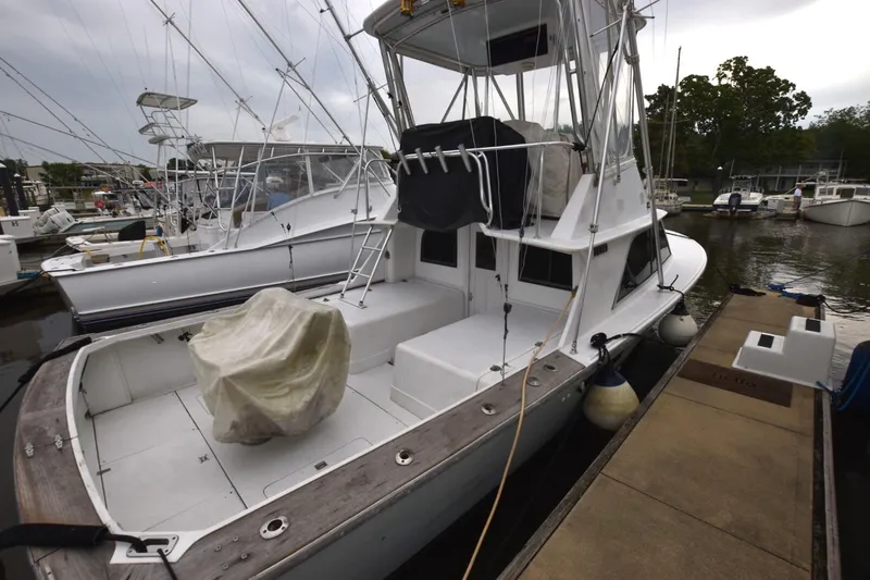 Slide: The Image of 1981 Blackfin 32 Sportfisherman docked, featuring spacious deck and fishing equipment. - 4