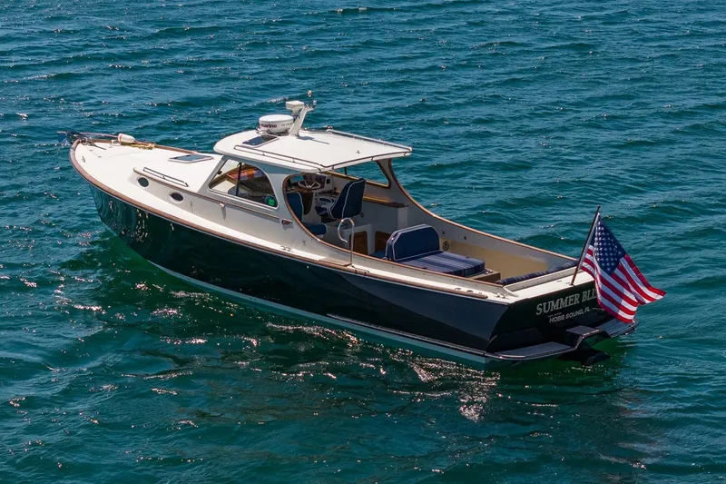 Slide: The Image of 2001 Hinckley Picnic Boat 36 Classic cruising on open water with American flag. - 11