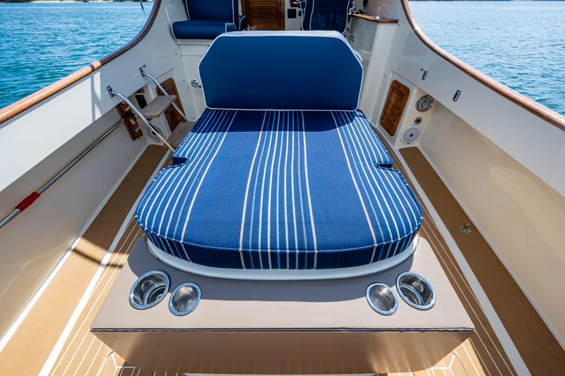 Slide: The Image of 2001 Hinckley Picnic Boat Classic with blue striped seating on deck, ocean view. - 22