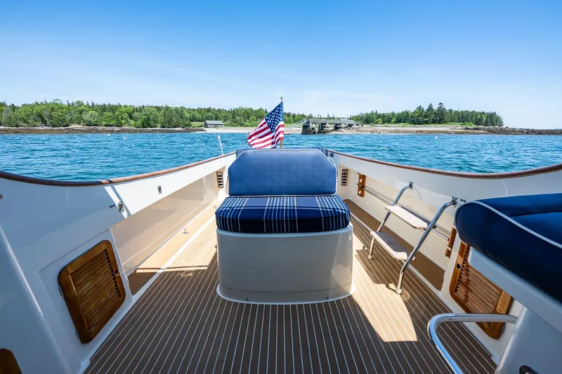 Slide: The Image of Hinckley Picnic Boat 36 Classic, 2001, with American flag, cruising on serene waters. - 26