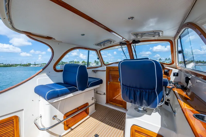 Slide: The Image of Interior of 2001 Hinckley Picnic Boat Classic with blue seating and wooden accents. - 27