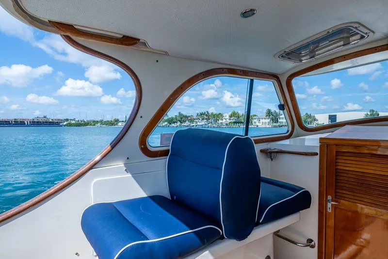 Slide: The Image of Interior view of 2001 Hinckley Picnic Boat Classic with blue seating and scenic water backdrop. - 28