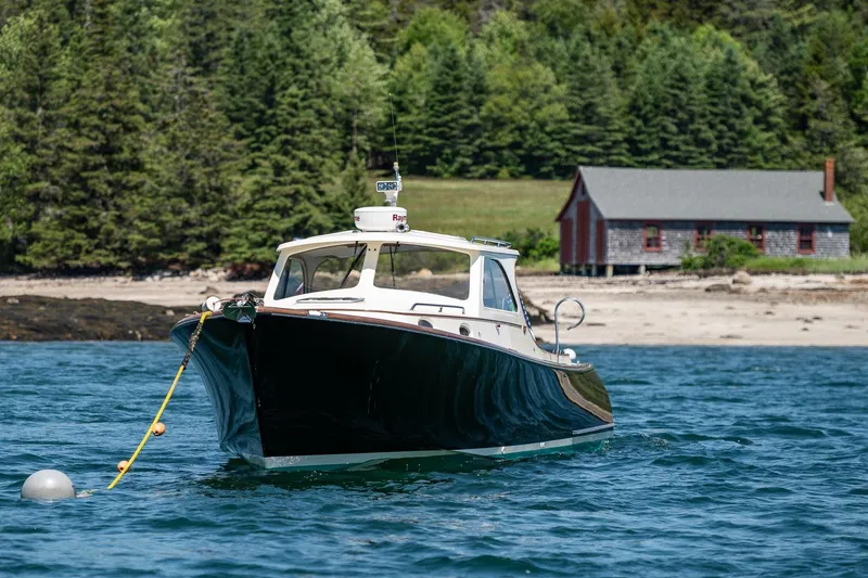 Slide: The Image of 2001 Hinckley Picnic Boat 36 Classic on water near a rustic shoreline. - 3