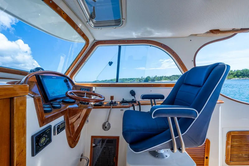 Slide: The Image of Interior of 2001 Hinckley Picnic Boat Classic with blue captain's chair and wooden dashboard. - 30