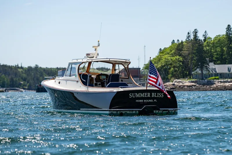 Slide: The Image of 2001 Hinckley Picnic Boat 36 Classic on water, American flag, scenic background. - 4