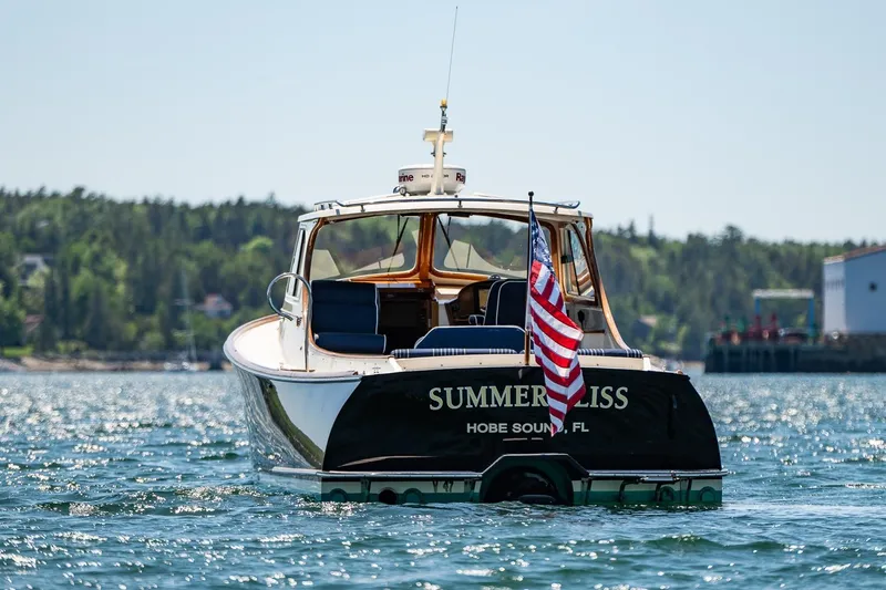 Slide: The Image of Hinckley Picnic Boat 36 Classic, 2001, named "Summer Bliss" on water, American flag displayed. - 5
