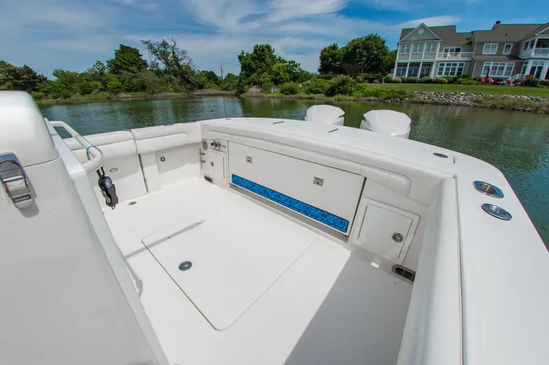 Slide: The Image of 2019 Regulator 31 boat interior with seating, storage, and scenic waterfront view. - 11