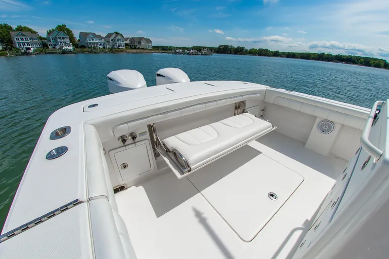 Slide: The Image of 2019 Regulator 31 boat with spacious seating, docked by waterfront homes under a clear blue sky. - 12