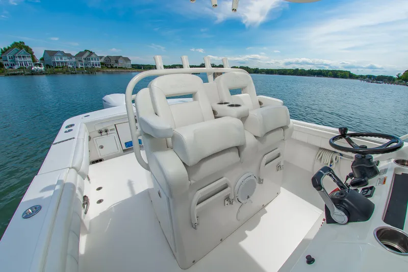 Slide: The Image of 2019 Regulator 31 boat interior with helm, white seating, and scenic waterfront view. - 15