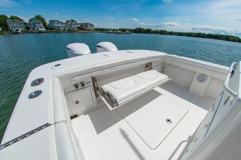 Slide: The Image of 2019 Regulator 31 boat with white seating, docked near waterfront homes. - 27